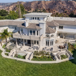 Striking Jake Paul House exterior featuring clean modern lines, expansive glass panels, and a manicured courtyard