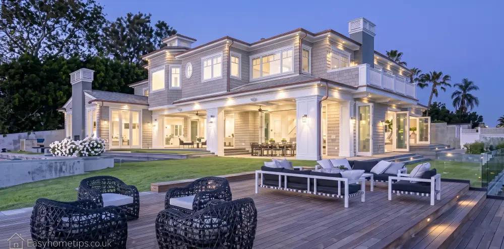 Breathtaking exterior of a sleek modern luxury mansion featuring pristine manicured gardens lining a sweeping grand driveway that leads to an elegant entrance.
